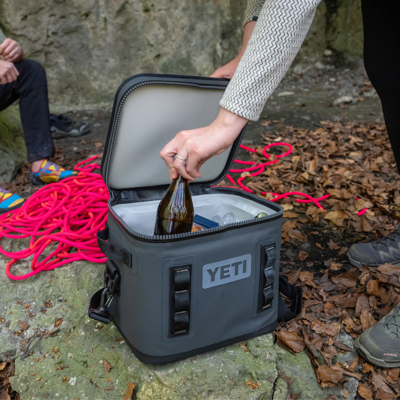 Yeti Hopper Flip 12 outside on rock with drink being grabbed