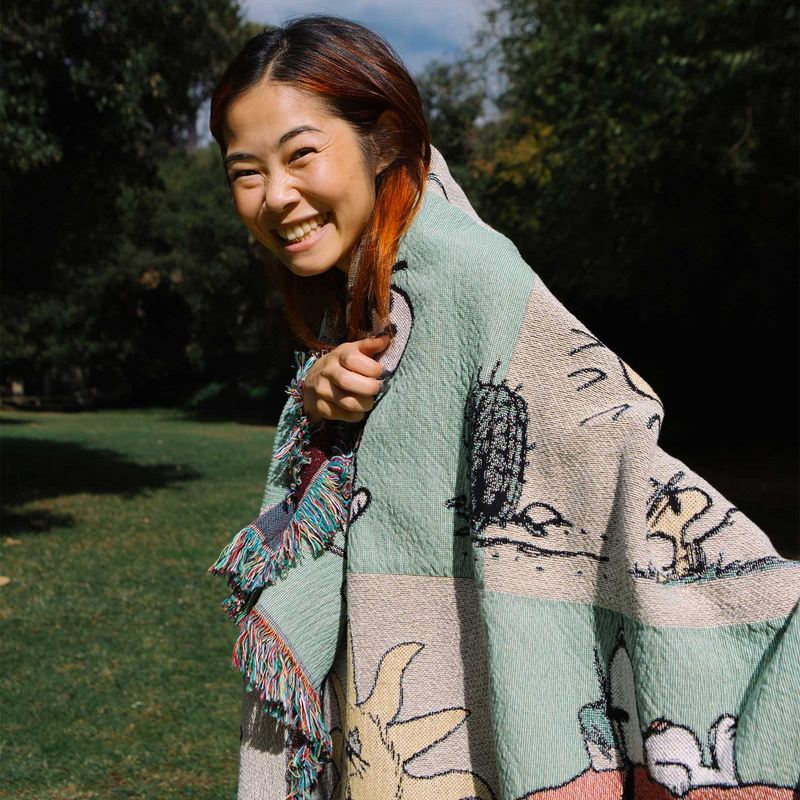 Peanuts x Parks Project Woven Blanket, Parks Project Peanuts x Parks Project Woven Blanket over shoulders
