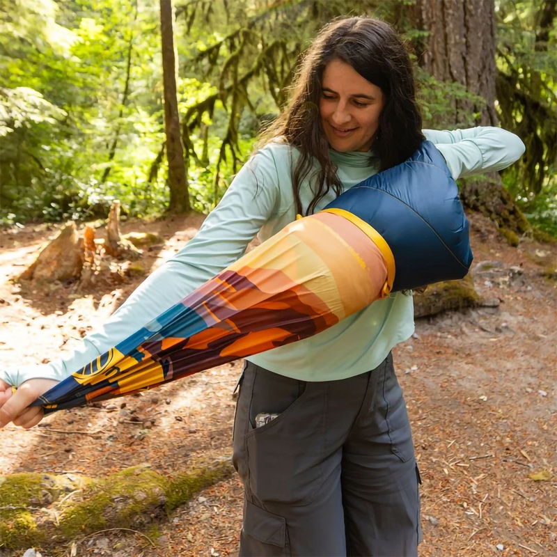 The Original Puffy Blanket, Rumpl The Original Puffy Blanket in Big Sur Fade with model in stuff sack