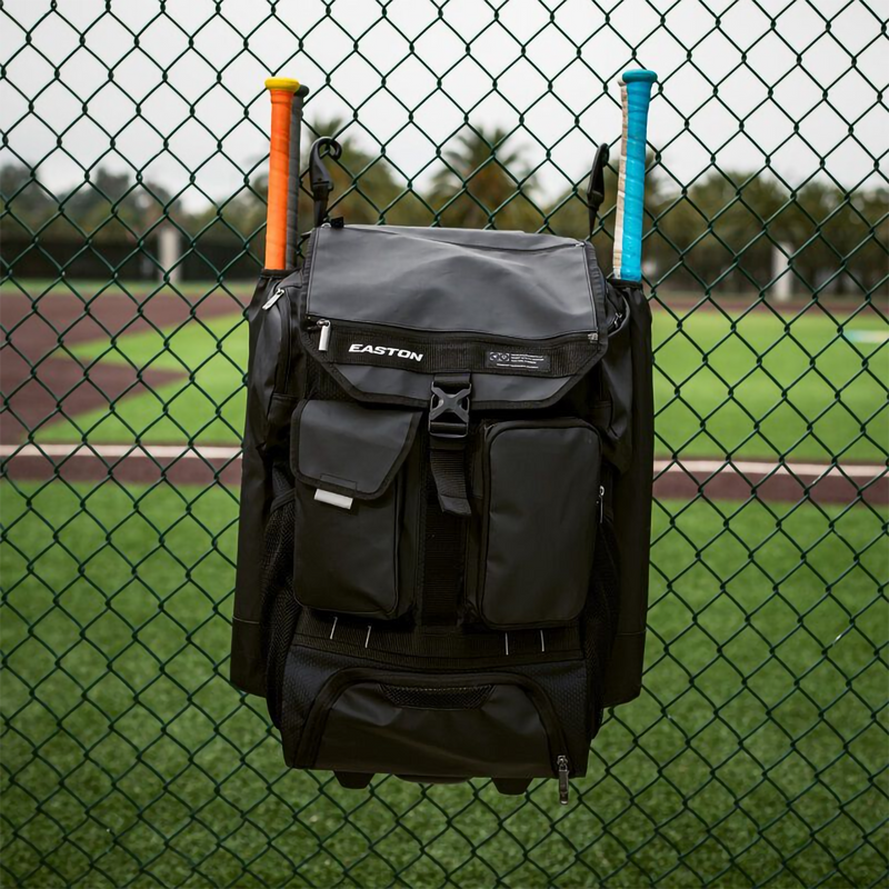 5 Tool Phenom Wheeled Bag, Easton Sports 5 Tool Phenom Wheeled Bag in Black hanging on fence