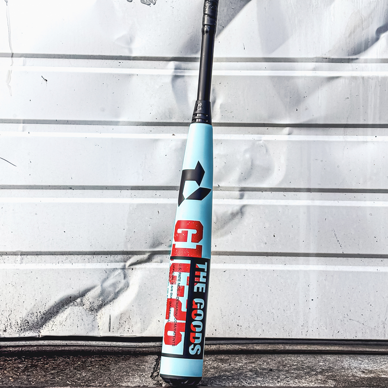 The Goods -3 BBCOR 2026, DeMarini The Goods -3 BBCOR 2026 in Tiffany/Red/Black on wall