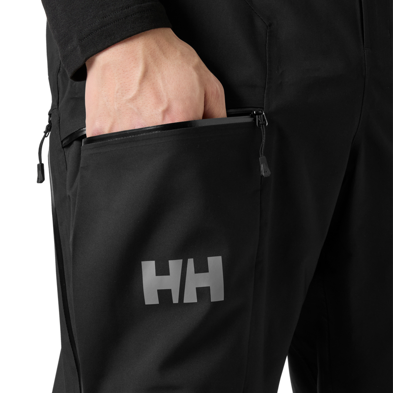 Helly Hansen Men's Verglas Backcountry Bib Shell Pants hand in zippered thigh pocket