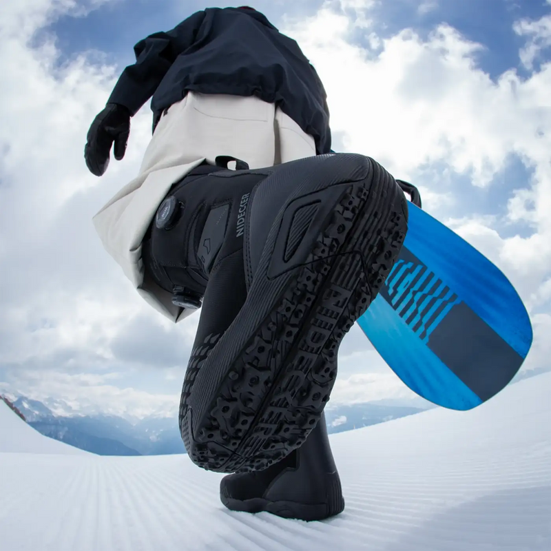 Niedecker Altai Wide bottom of boot on snowboarder walking on snow with board