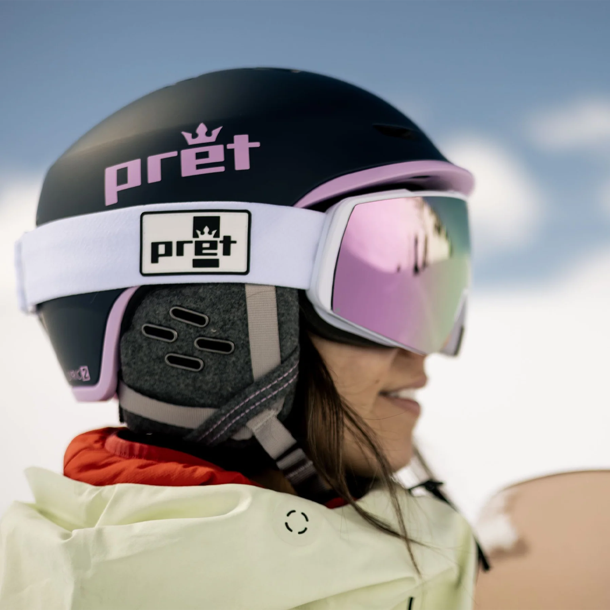 Pret Women's Lyric 2 side view of skier wearing helmet with goggles